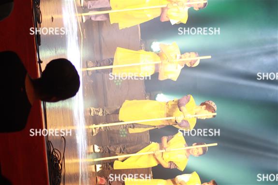 ילדים בהצגה עם תלבושת צהובה ומקל בידם